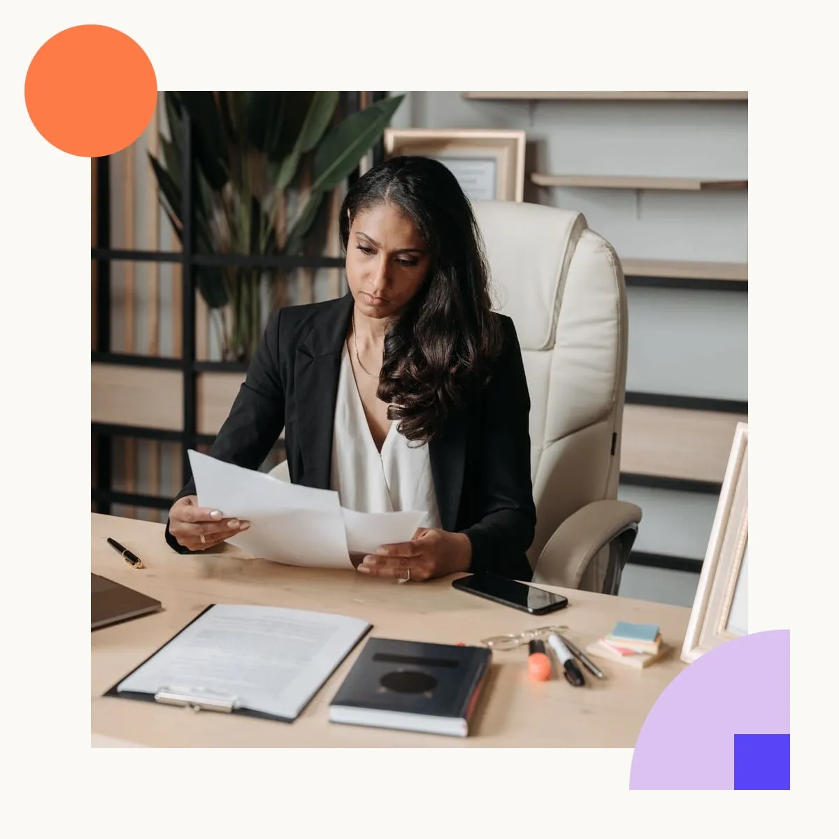A business owner reading a printed invoice at her desk, laptop open beside her