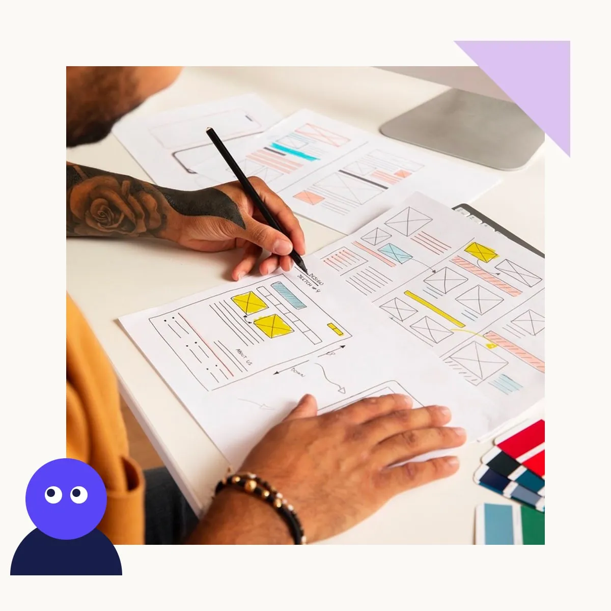 A designer sketching website wireframes on paper at a desk