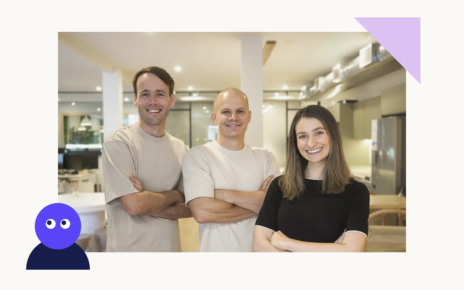 Three smiling team members standing with arms crossed in a bright office