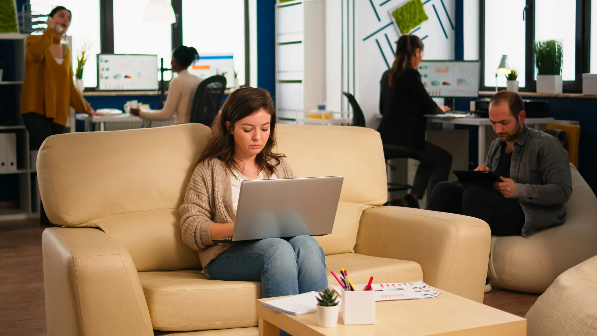 A woman working on a laptop from the sofa