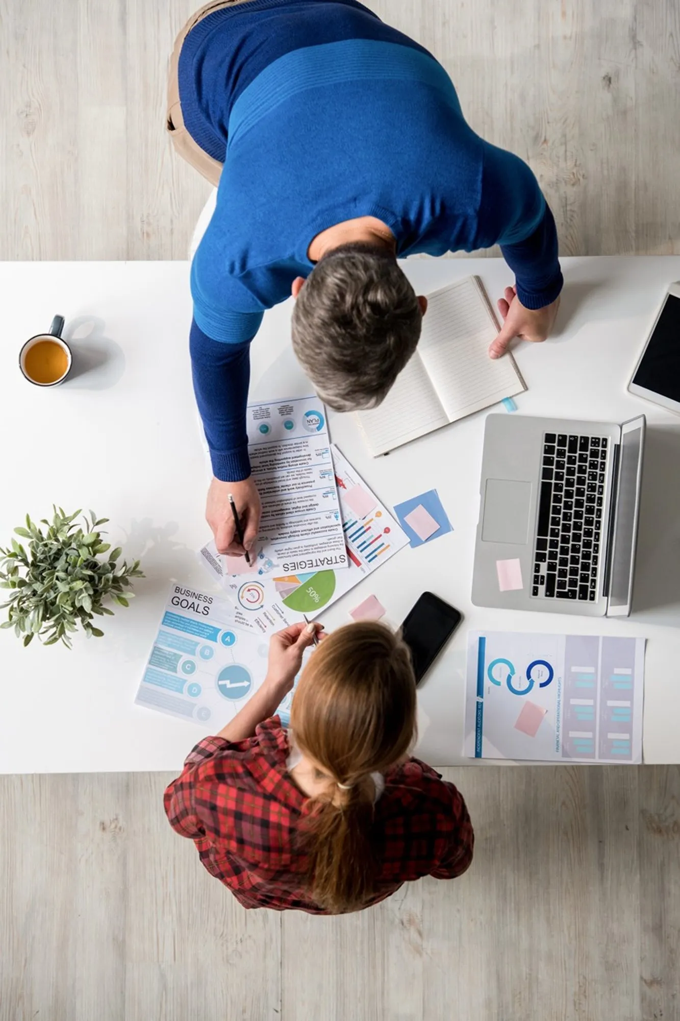 A team planning a project around a table, seen from above